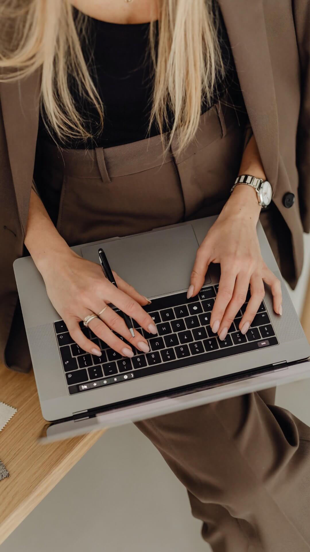 Woman sitting on a bench typing on her laptop